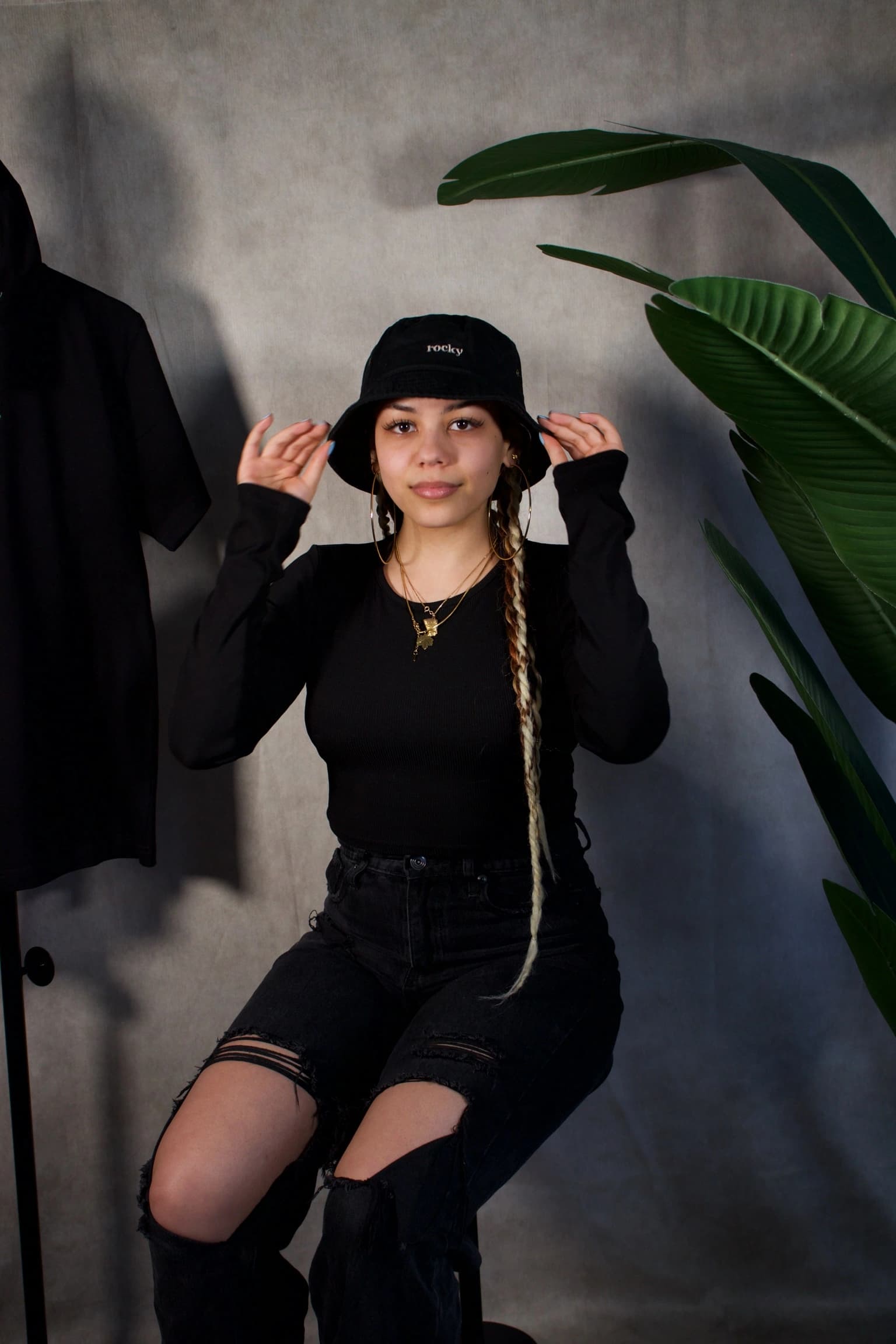 Person with dreadlocks wearing black long-sleeved top and bucket hat